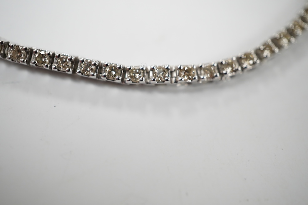 A modern 9ct white metal and diamond set tennis bracelet, with a total diamond weight of 1.50ct, 17.3cm, gross weight 6.6 grams. Condition - good